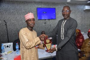 Isa Muhammad Yusuf receiving an award from Sani Maikatanga